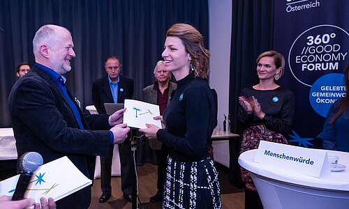 Nina Simmel erhält offiziell das GWÖ-Zertifikat für Alpenland überreicht.